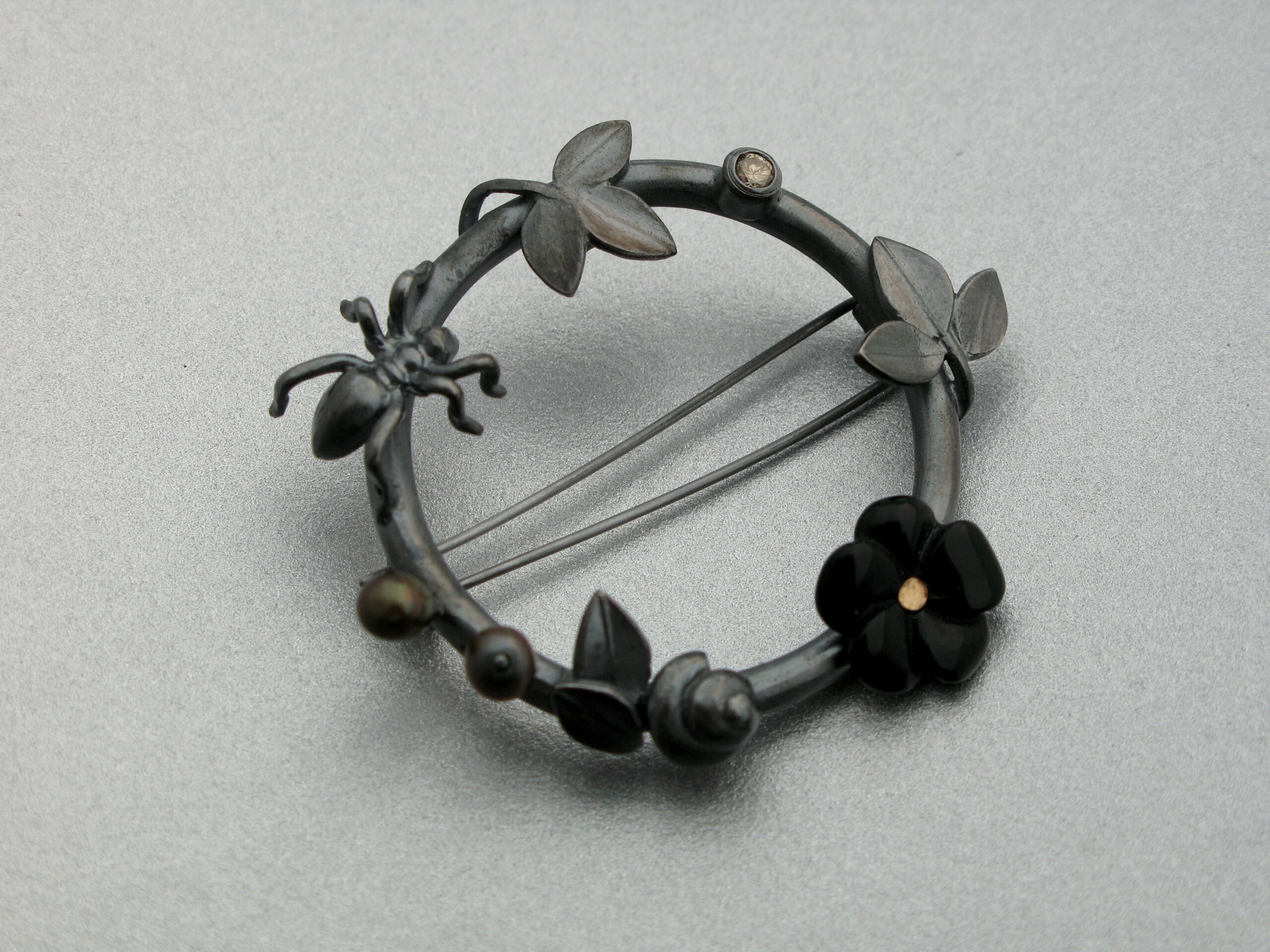 Brosch, ”Krans”, oxiderat silver, sötvattenspärla, onyx och brun briljant